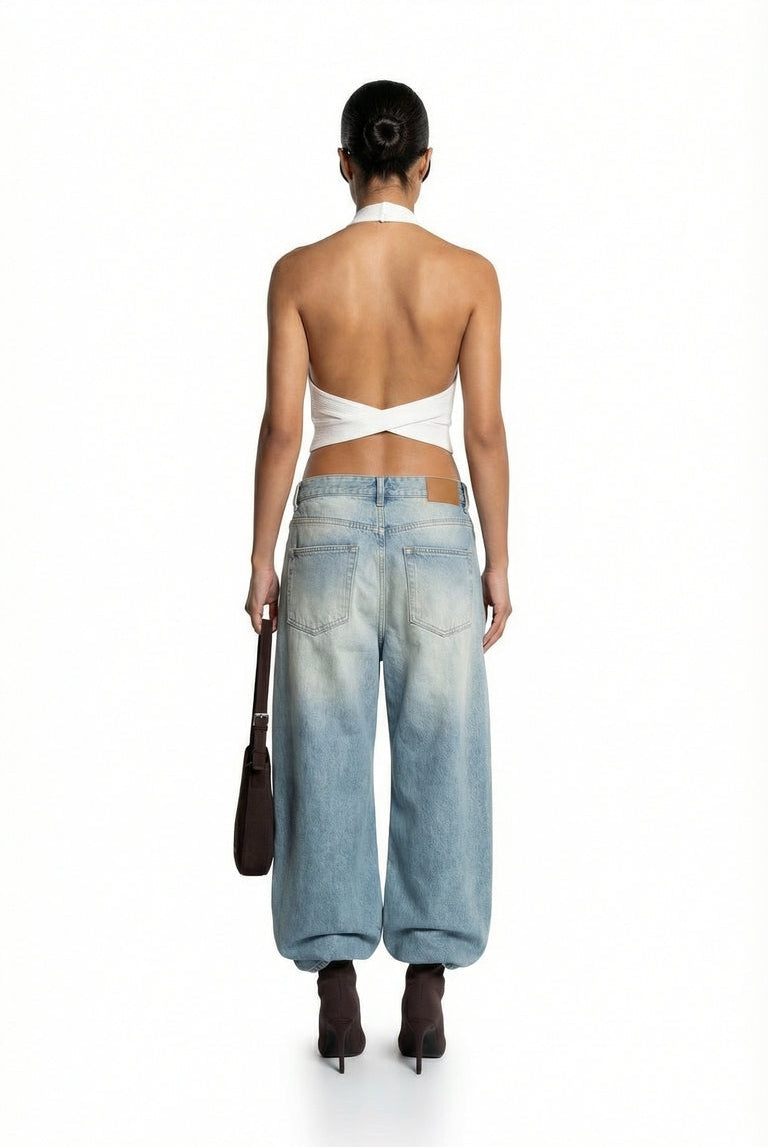 Person wearing a white top and light blue jeans on a white background